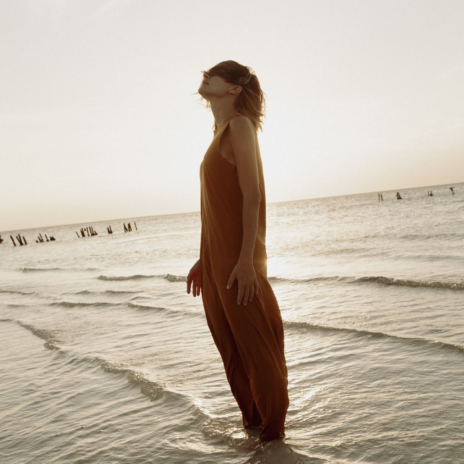 Guest standing in the sea at sunset
